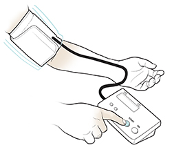 Person using blood pressure monitor at home, with cuff on arm.